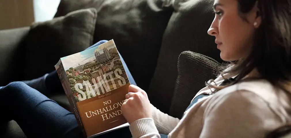 A woman reading a copy of the book: "Saints"