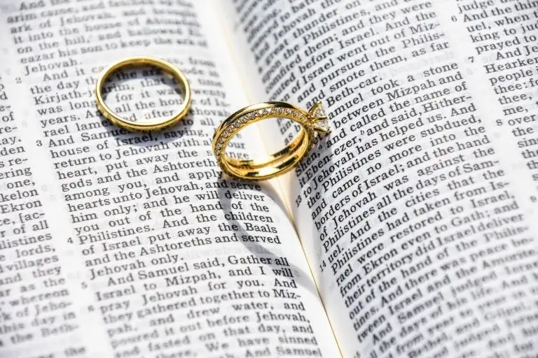 Two wedding rings on top of open pages of the Bible.
